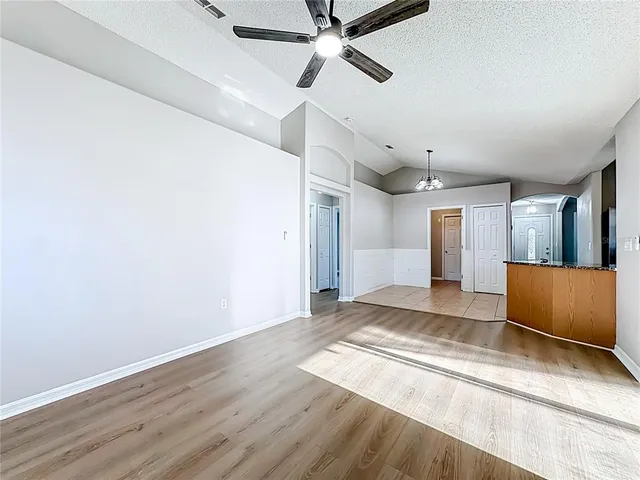 a view of a room with wooden floor and ceiling fan