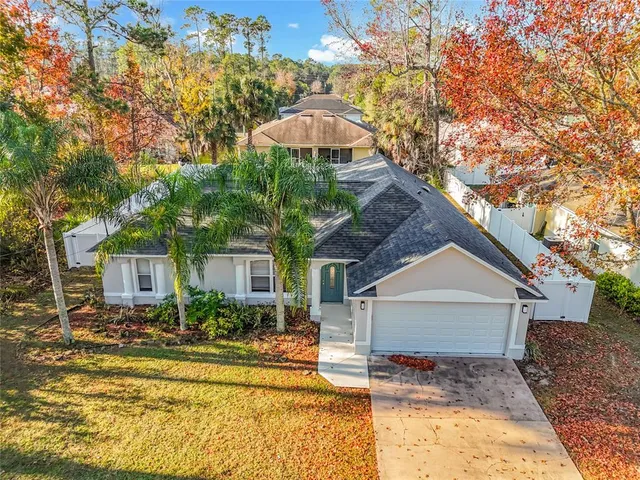 a front view of a house with a yard and trees