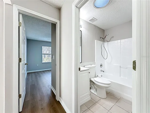 a bathroom with a toilet sink a mirror and shower