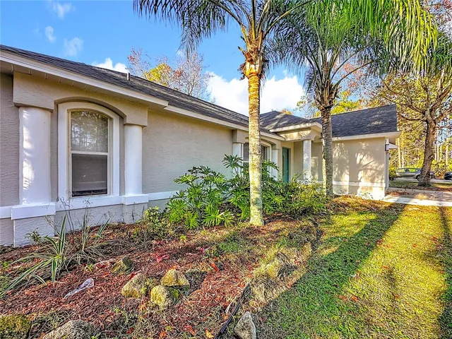 a front view of a house with garden and patio