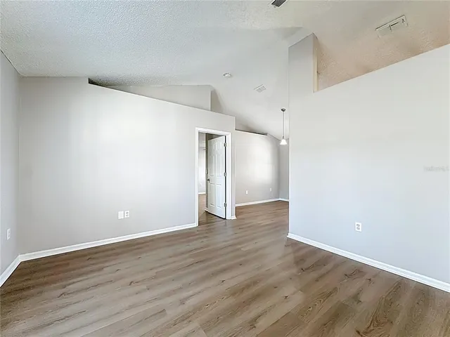 a view of an empty room with wooden floor