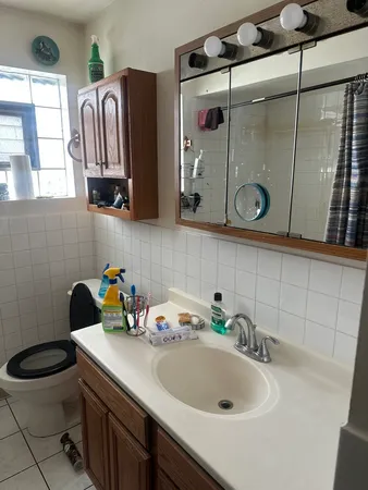 a bathroom with a sink a toilet and a mirror