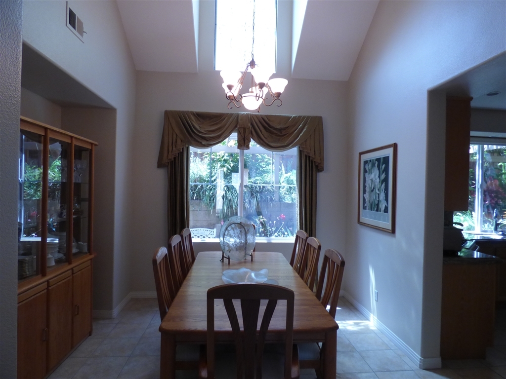684 Poets Square Fallbrook, CA 92028 - Photo 4 of 25 Separate dining room with vaulted ceiling and decorative lead glass window.