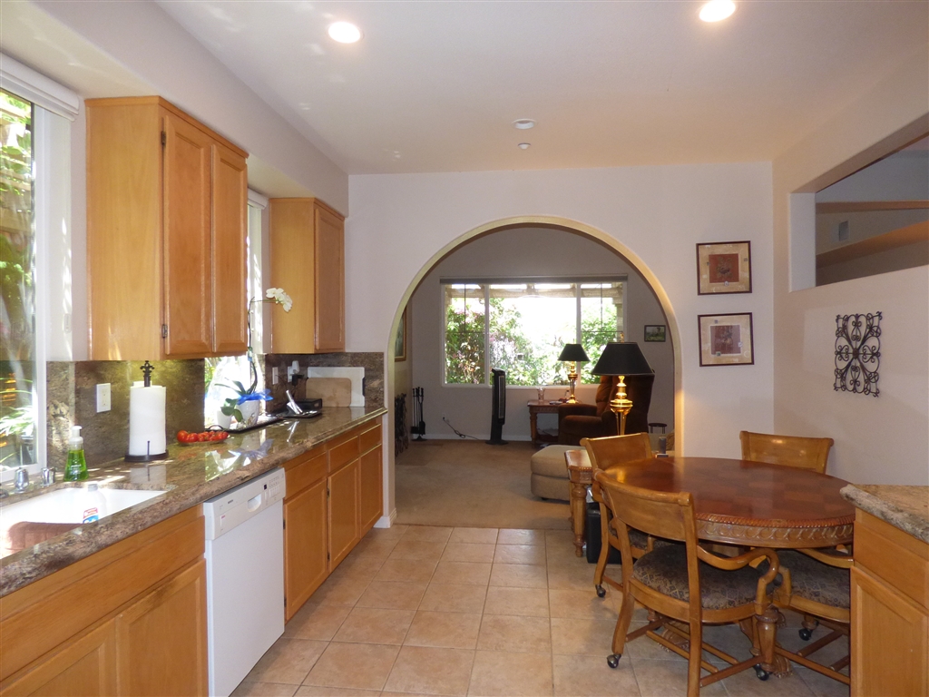 684 Poets Square Fallbrook, CA 92028 - Photo 6 of 25 Large alley kitchen with gas cooking, granite counters and large windows to the outside garden.