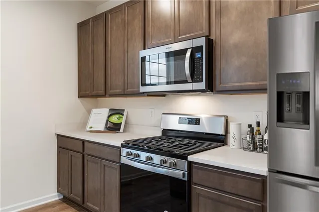 a kitchen with stainless steel appliances a stove a microwave a sink and cabinets