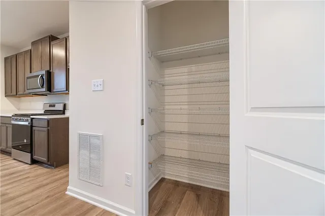 a view of walk in closet with wooden floor