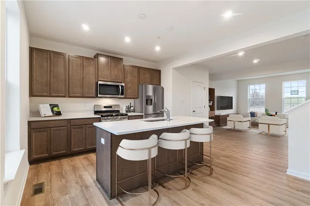 a kitchen with table chairs cabinets and stainless steel appliances
