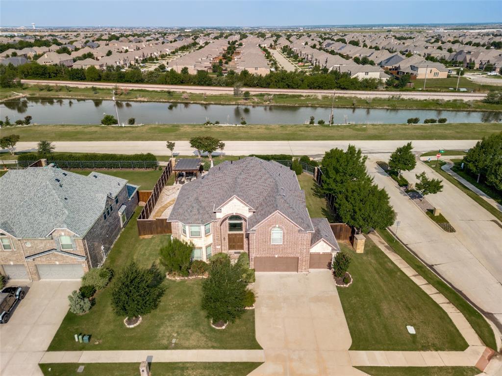 1461 Ramsbury Lane Prosper, TX 75078 - Photo 27 of 30 Brick and stone exterior with a prominent arched window and a covered entry