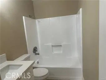 a white toilet sitting next to a bath tub