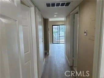 a hallway with wooden floor and closet