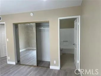 an empty room with wooden floor and closet