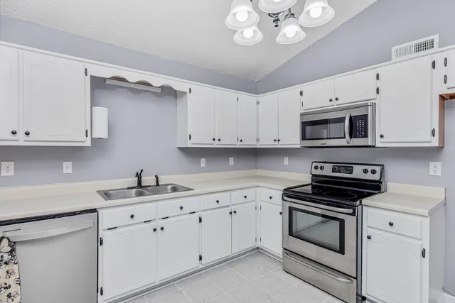 a kitchen with white cabinets and white appliances