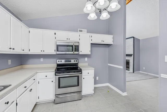 a kitchen with cabinets stainless steel appliances and a counter space