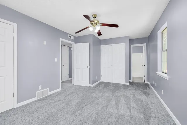 a view of an empty room with a ceiling fan