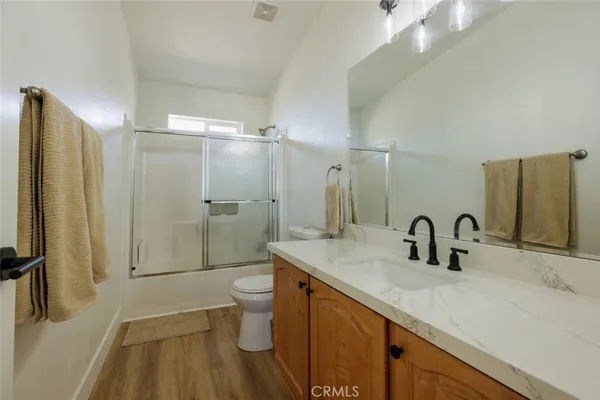 a bathroom with a double vanity sink toilet and shower