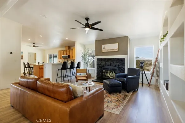 a living room with furniture a fireplace and wooden floor
