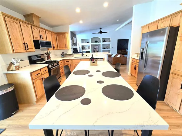 a kitchen with stainless steel appliances kitchen island granite countertop a sink and a refrigerator