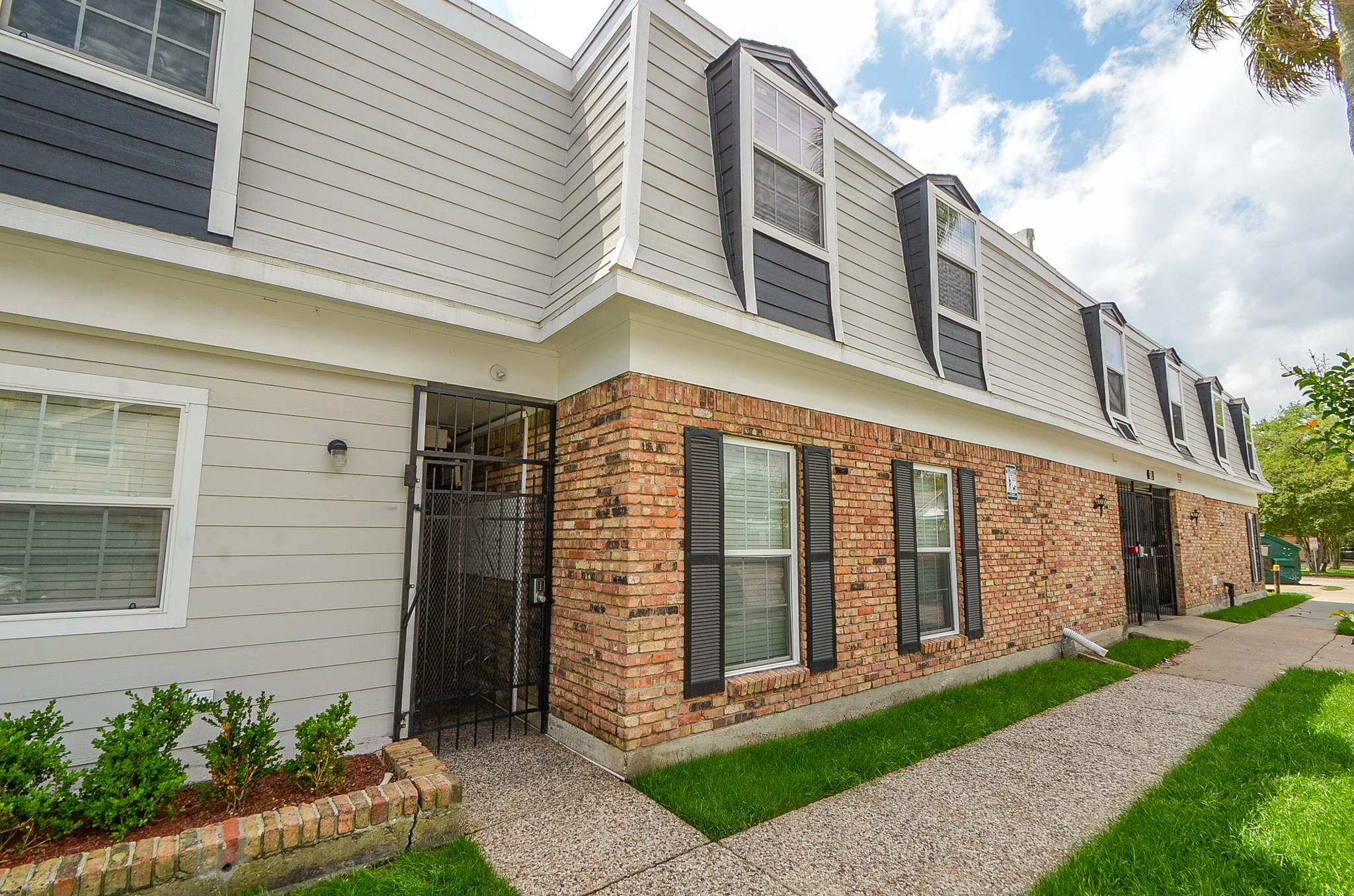 a front view of a building with a garden