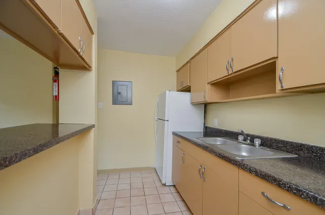 a kitchen with granite countertop a sink a stove and a refrigerator