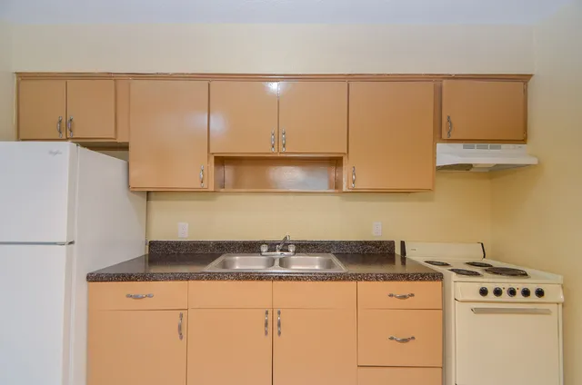 a kitchen with granite countertop white cabinets and a sink