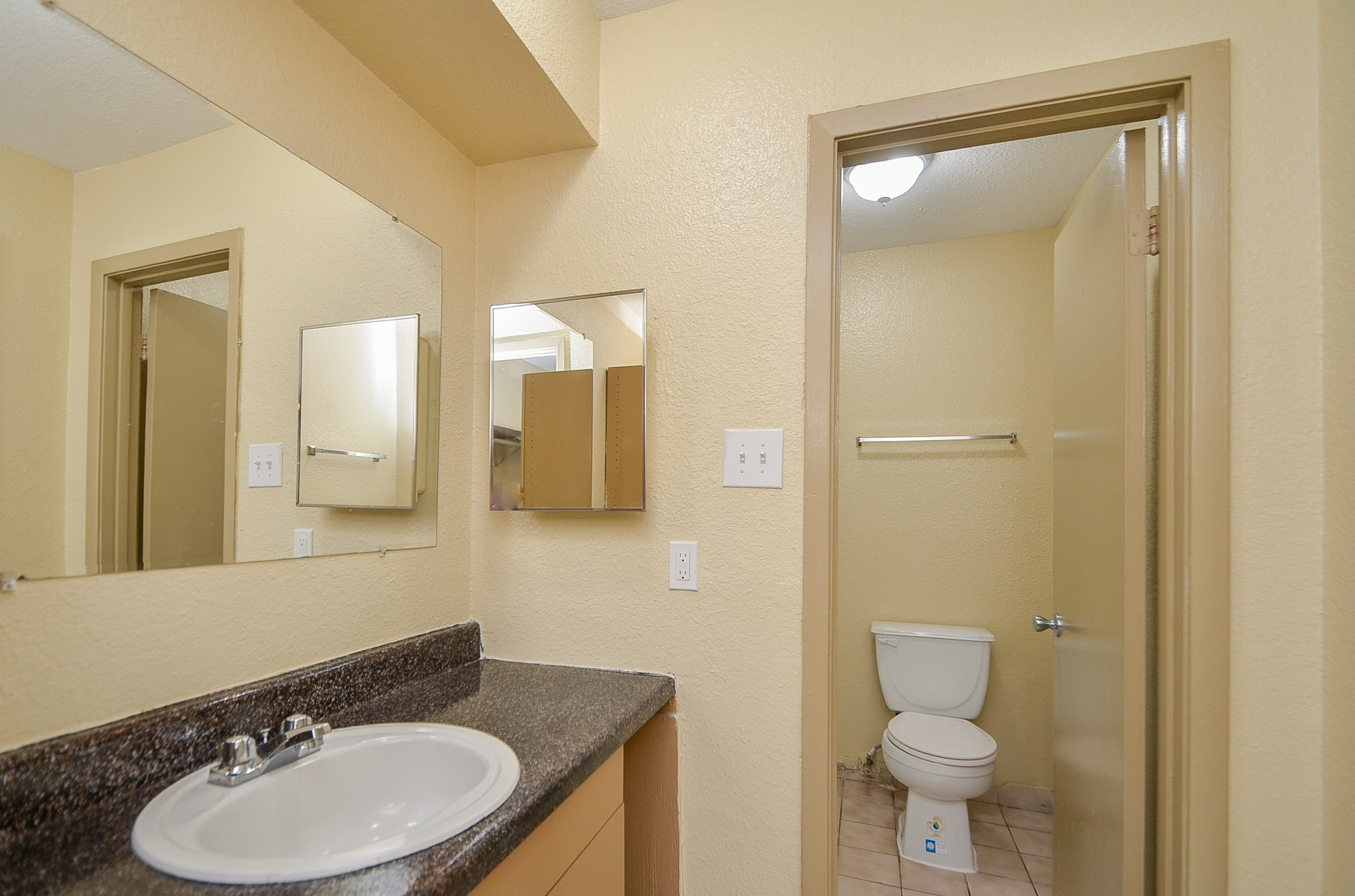 1419 Hawthorne Street, Unit 21 Houston, TX 77006 - Photo 19 of 24 a bathroom with a granite countertop sink toilet a mirror and shower