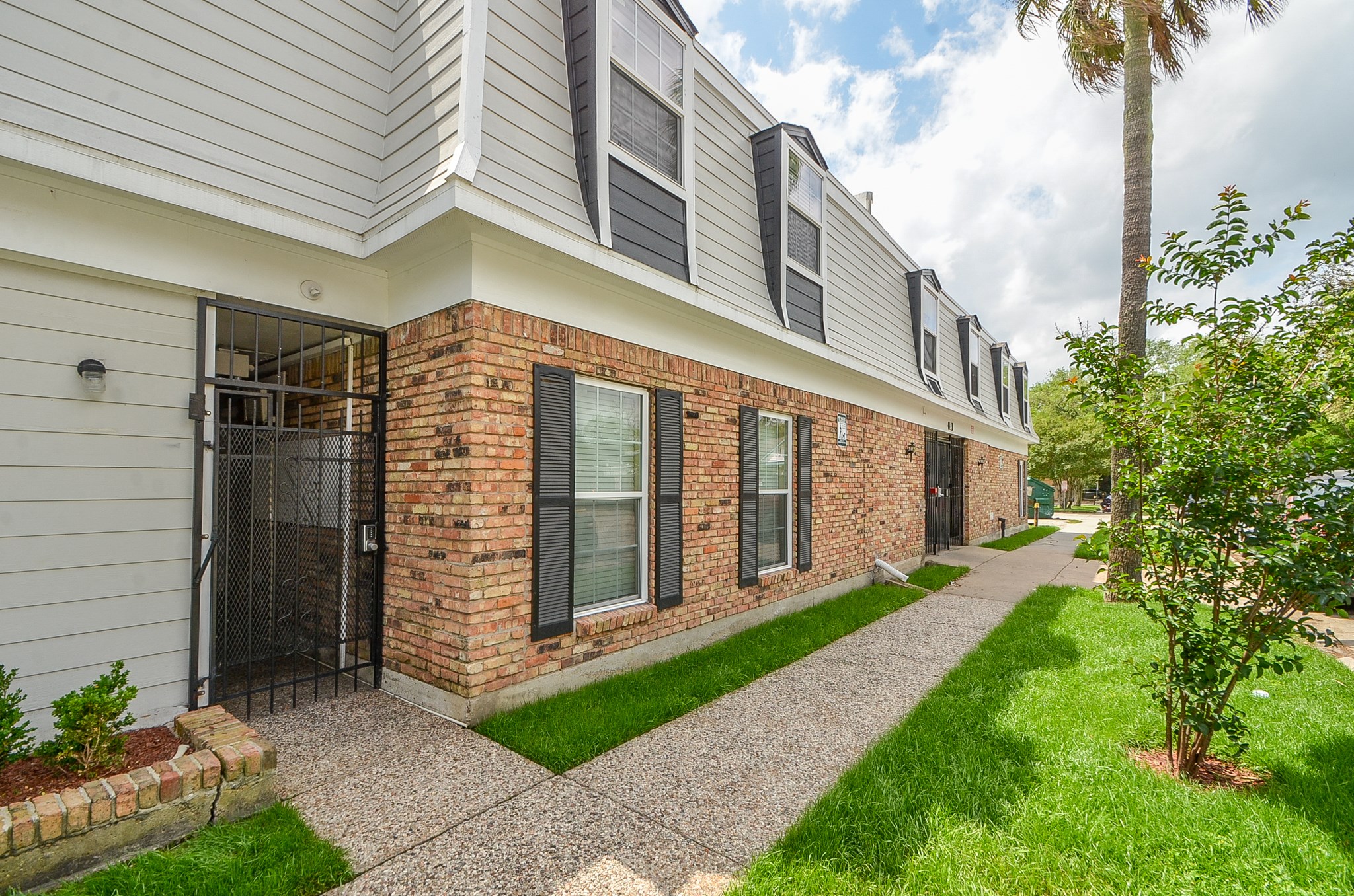 1419 Hawthorne Street, Unit 21 Houston, TX 77006 - Photo 3 of 24 a view of a brick house with a yard and potted plants
