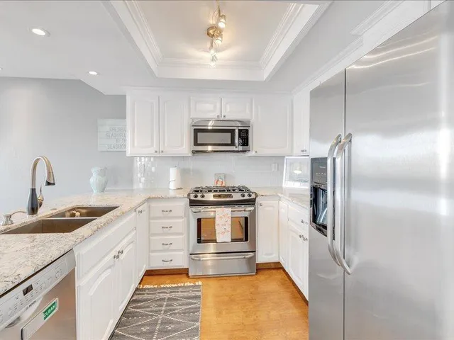 a kitchen with stainless steel appliances granite countertop a stove a sink and a refrigerator