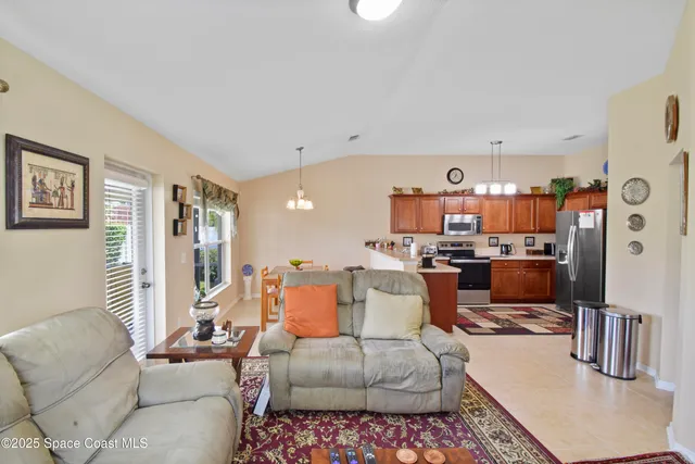 a living room with furniture and a view of kitchen