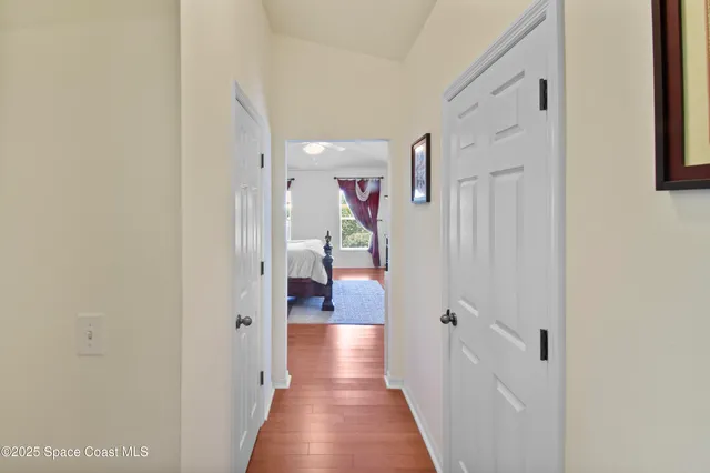 a view of a hallway with wooden floor and closet