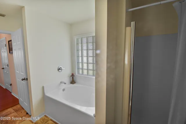a white bath tub sitting next to a shower