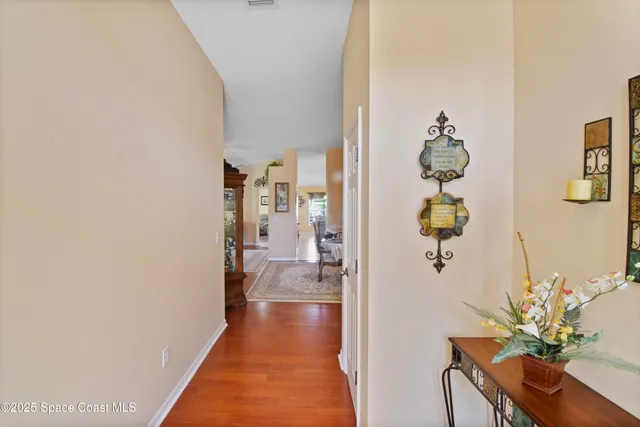 a hallway with a potted plant on the wall and a table
