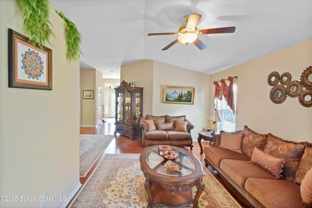a living room with furniture a chandelier and a window