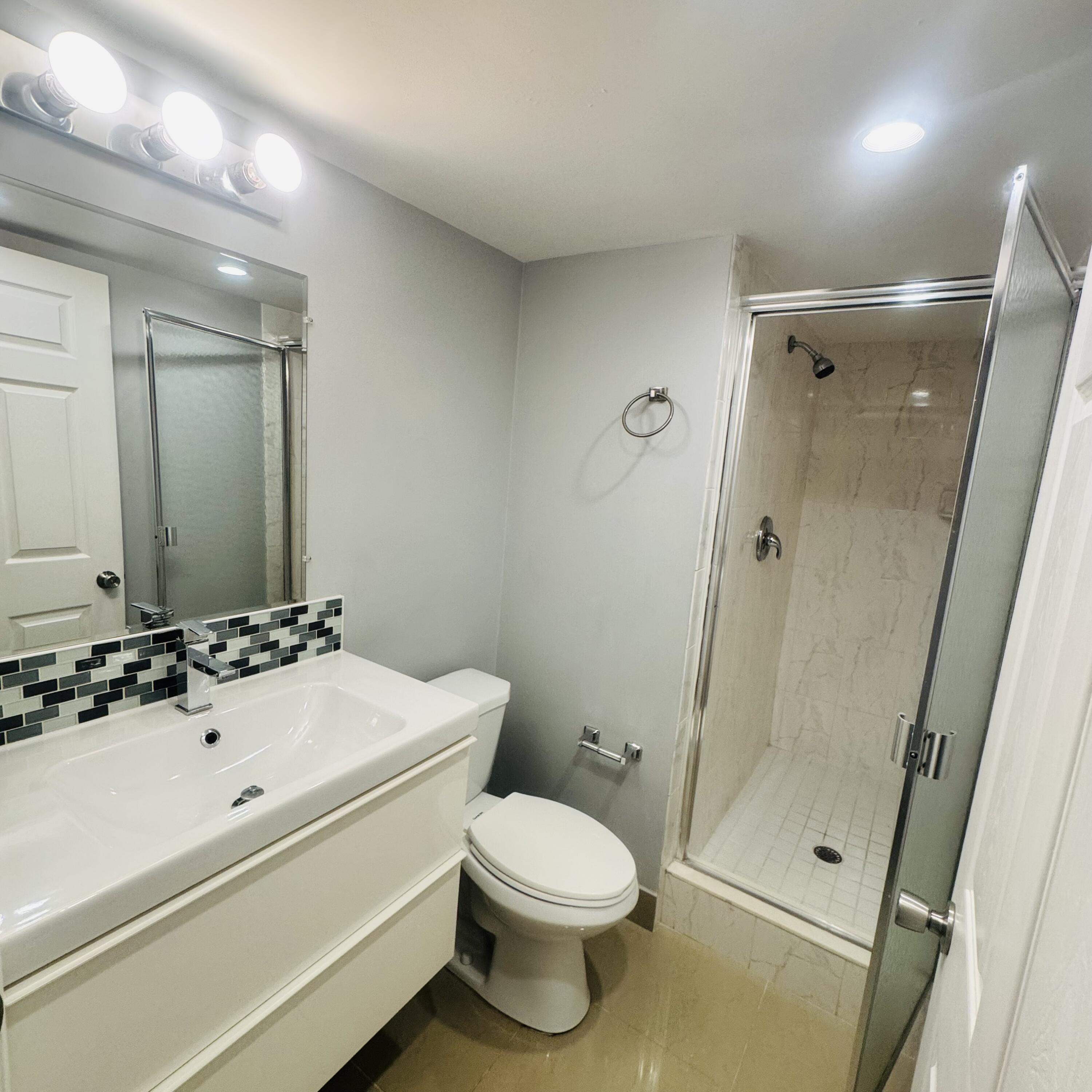 9235 Southwest 8th Street, Unit 503 Boca Raton, FL 33428 - Photo 17 of 17 a bathroom with a sink a toilet and shower