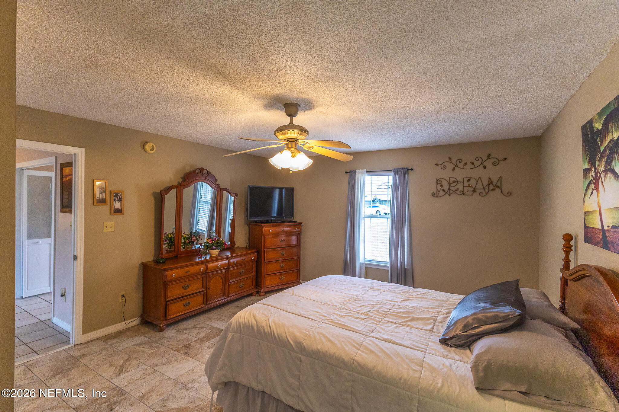 6110 4th Manor West Palatka, FL 32177 - Photo 42 of 44 a bedroom with a bed and a chandelier