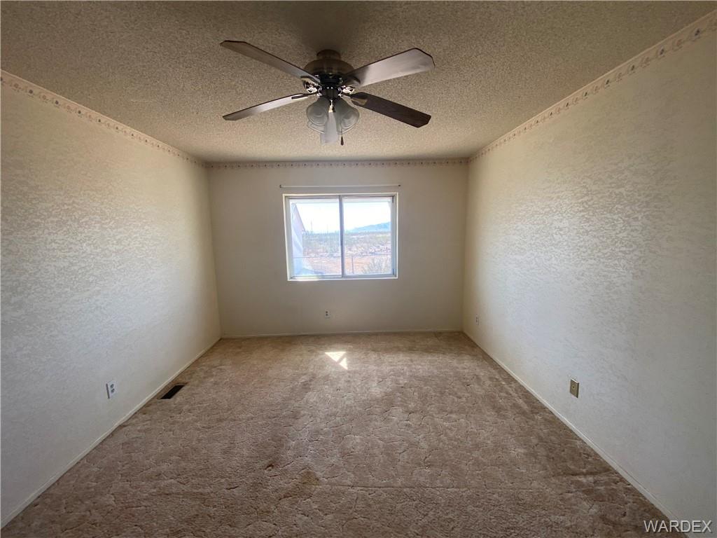 4649 Eden Road Golden Valley, AZ 86413 - Photo 11 of 26 an empty room with a window and a ceiling fan