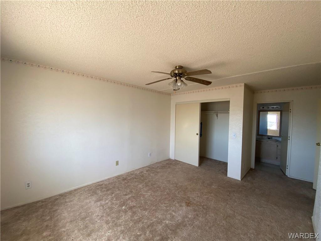 4649 Eden Road Golden Valley, AZ 86413 - Photo 12 of 26 an empty room with closet and a chandelier fan