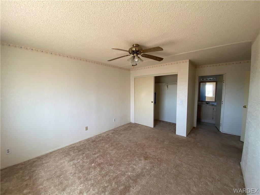4649 Eden Road Golden Valley, AZ 86413 - Photo 13 of 26 an empty room with a ceiling fan and a window