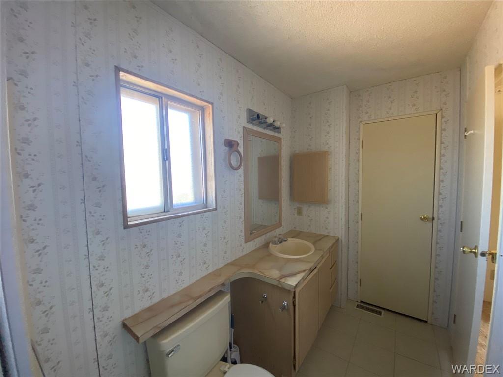 4649 Eden Road Golden Valley, AZ 86413 - Photo 15 of 26 a bathroom with a granite countertop sink a toilet and shower