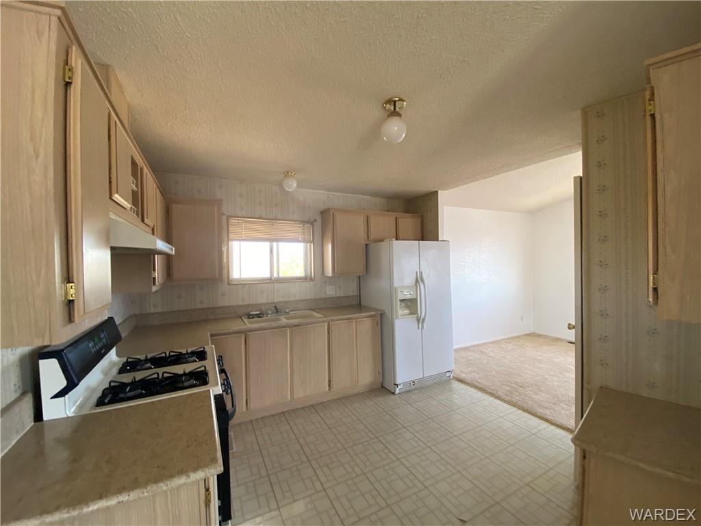 4649 Eden Road Golden Valley, AZ 86413 - Photo 8 of 26 a kitchen with stainless steel appliances granite countertop a refrigerator and a stove