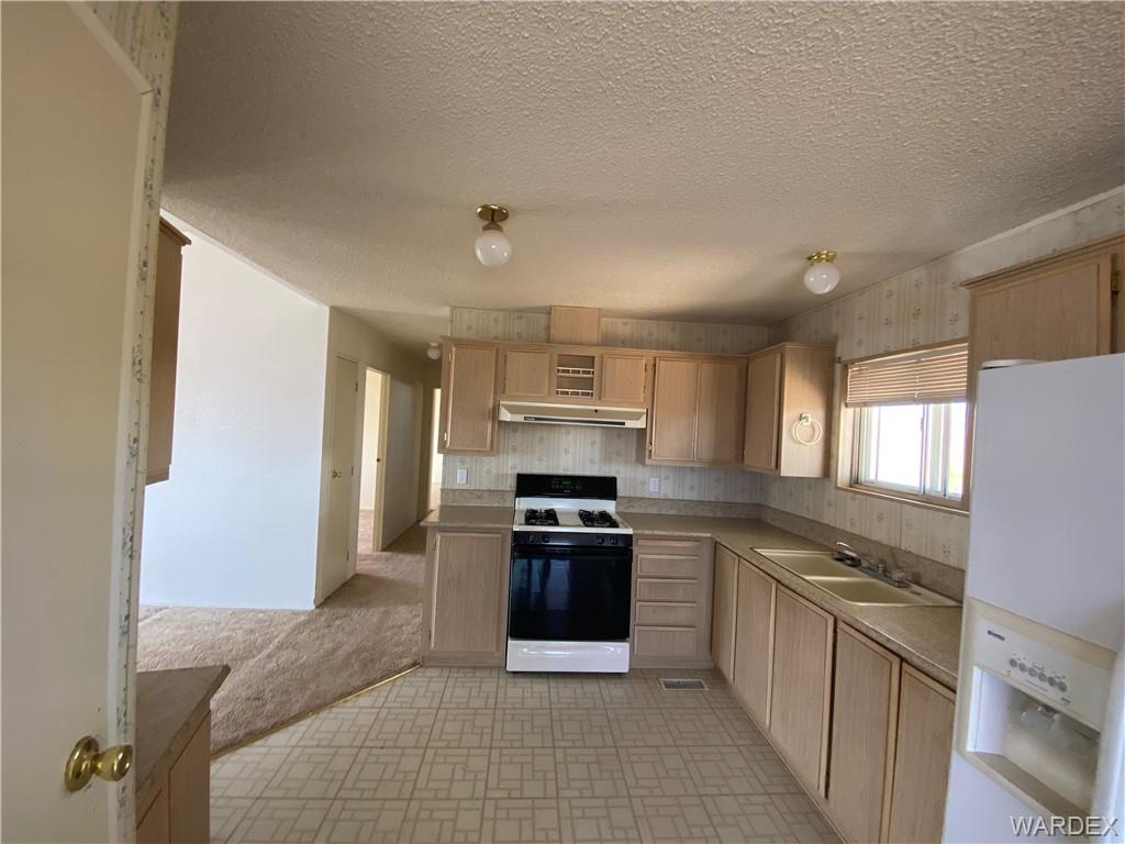 4649 Eden Road Golden Valley, AZ 86413 - Photo 9 of 26 a kitchen with stainless steel appliances granite countertop a stove and a refrigerator