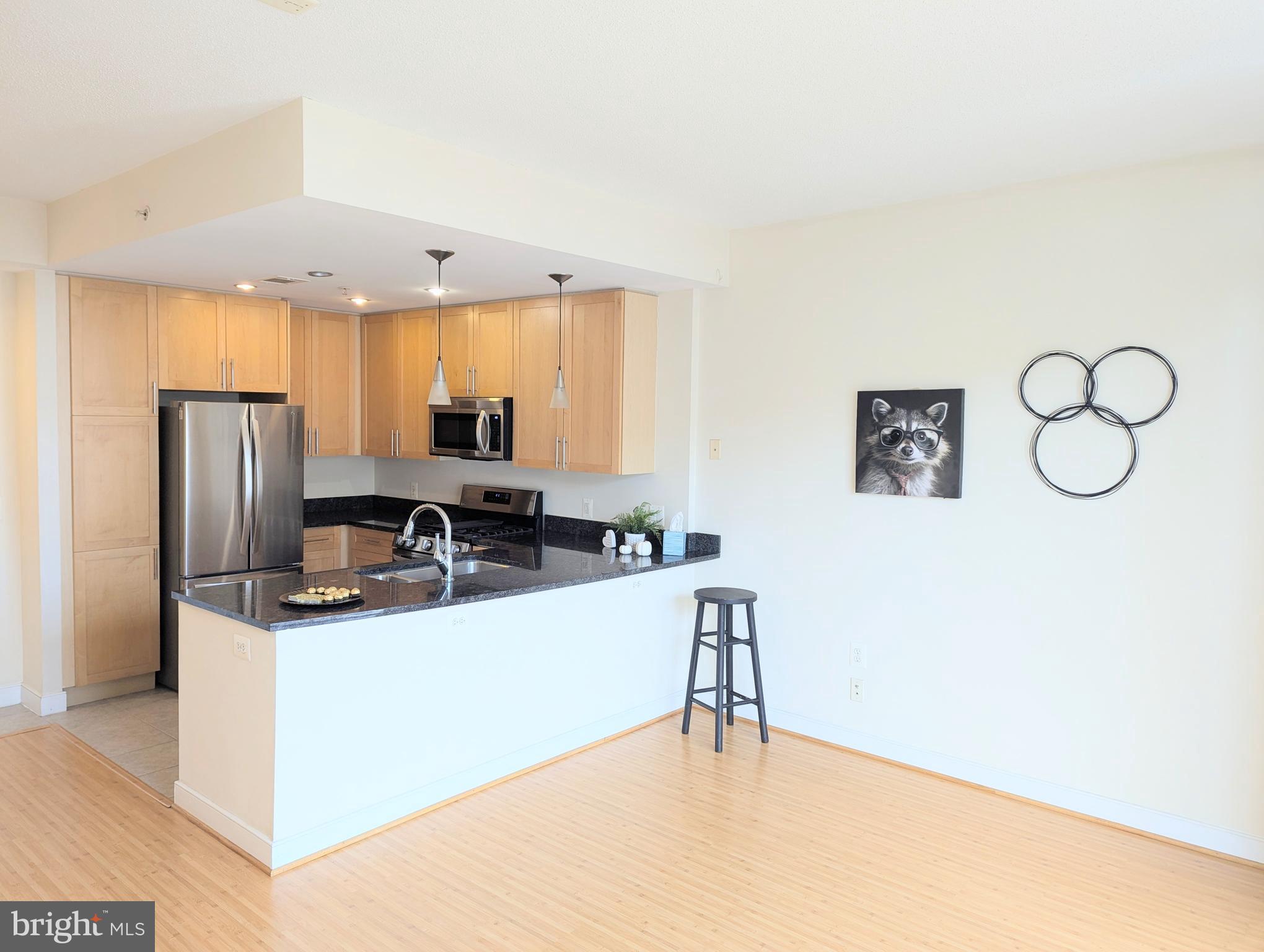 a kitchen with stainless steel appliances a refrigerator a sink a stove and white cabinets