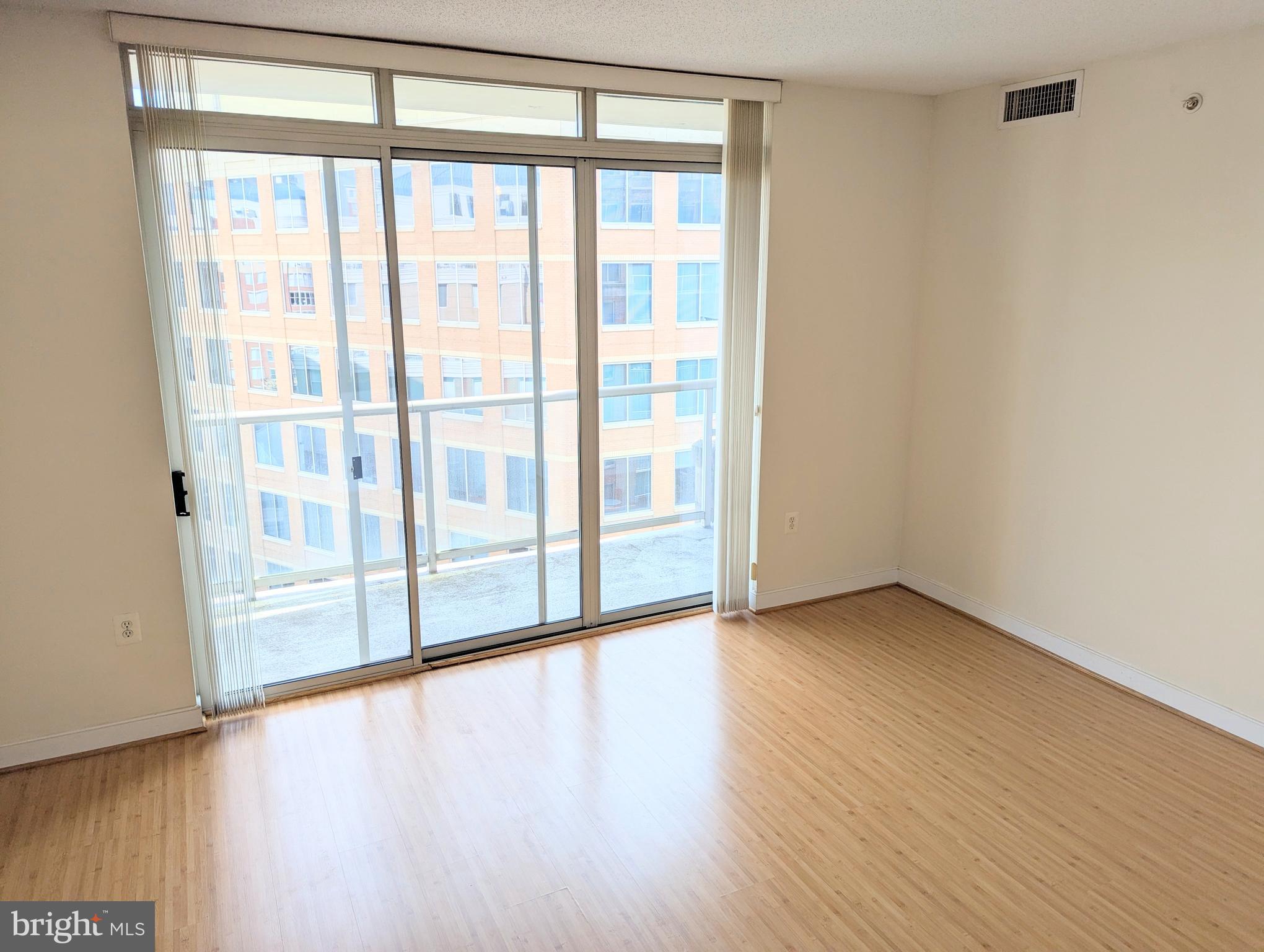 820 North Pollard Street, Unit 810 Arlington, VA 22203 - Photo 10 of 49 a view of an empty room with wooden floor and a window