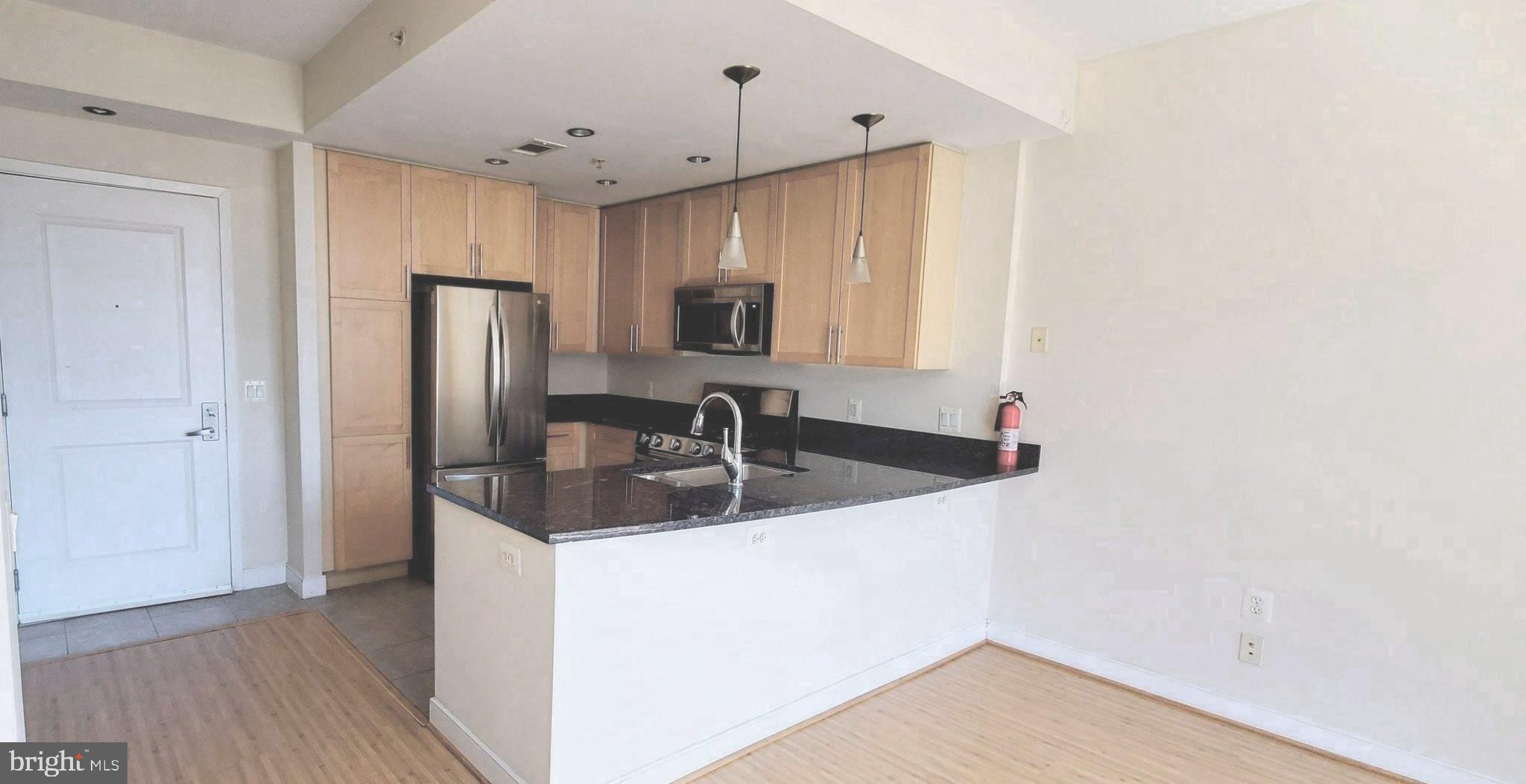 820 North Pollard Street, Unit 810 Arlington, VA 22203 - Photo 11 of 49 a kitchen with stainless steel appliances granite countertop a sink a refrigerator and a granite counter tops