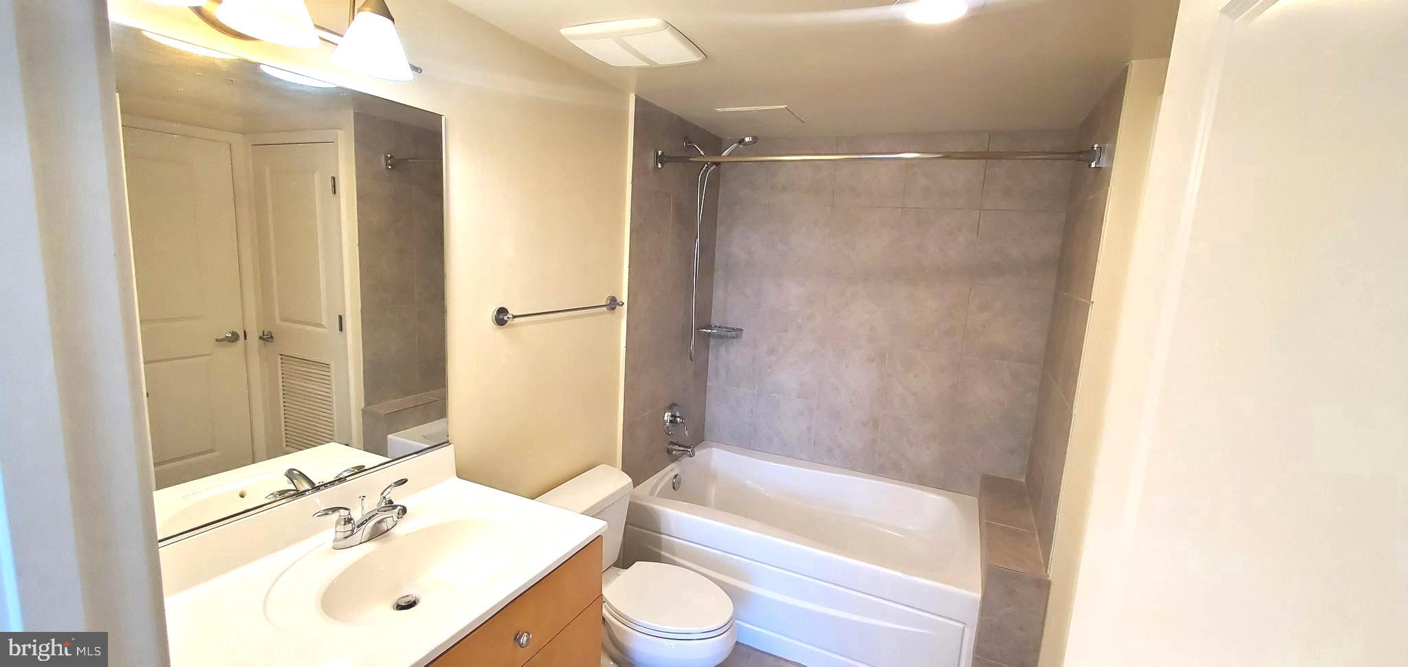 820 North Pollard Street, Unit 810 Arlington, VA 22203 - Photo 29 of 49 a bathroom with a bathtub shower sink vanity and a toilet