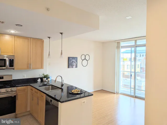 a kitchen with a faucet a chandelier and living room view