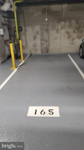 a living room with stainless steel appliances furniture a rug and a kitchen