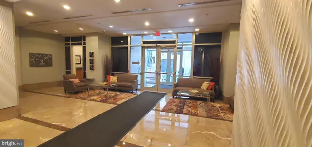 a view of a living room with furniture and floor to ceiling window