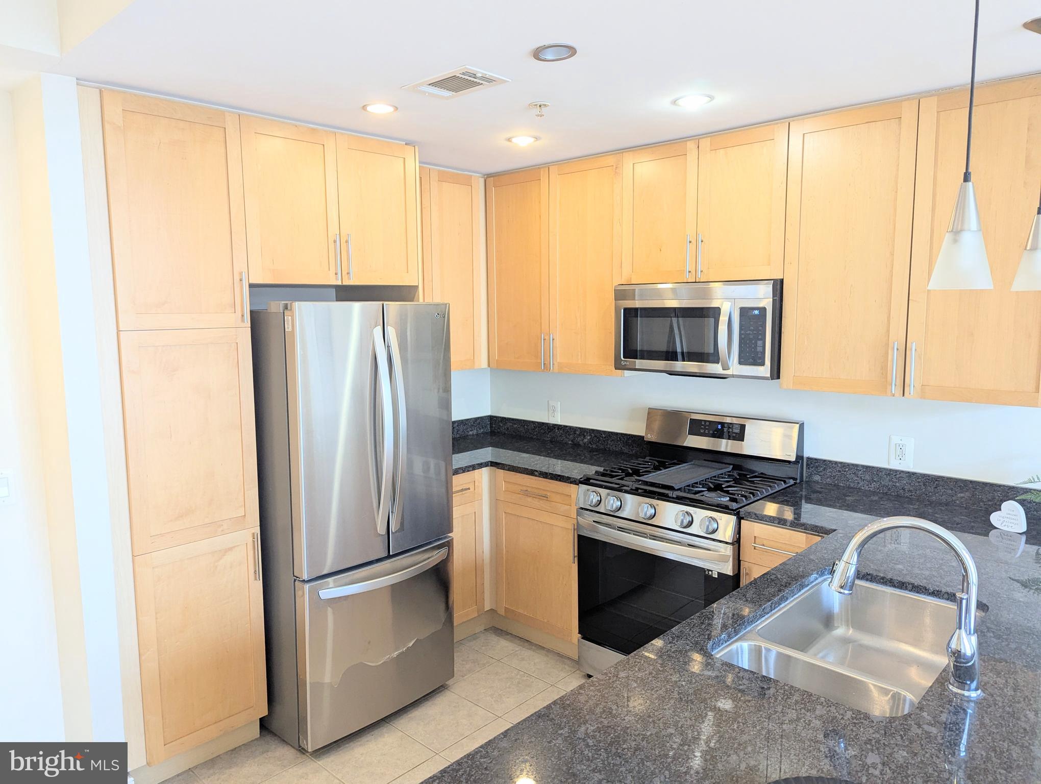 820 North Pollard Street, Unit 810 Arlington, VA 22203 - Photo 4 of 49 a kitchen with stainless steel appliances granite countertop a refrigerator a stove a sink and a microwave
