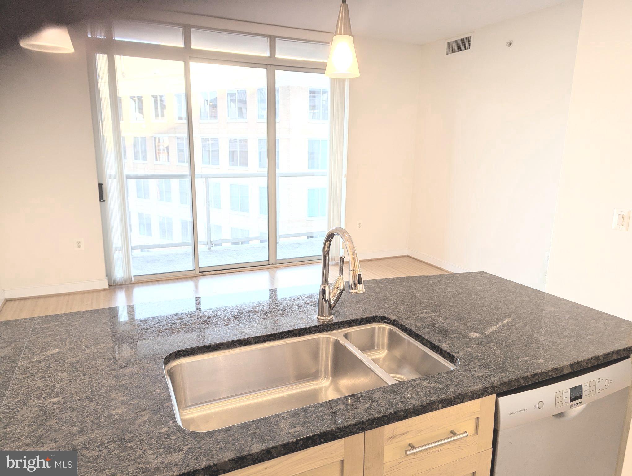 820 North Pollard Street, Unit 810 Arlington, VA 22203 - Photo 6 of 49 a kitchen with granite countertop a sink and a large window