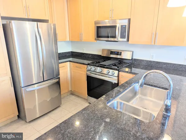 a kitchen with granite countertop a sink and a large window